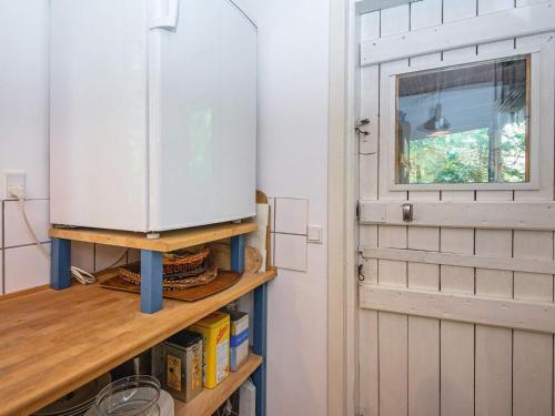 a kitchen with a refrigerator on a shelf next to a door at 4 person holiday home in Bryrup-By Traum in Bryrup