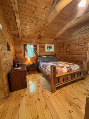 a bedroom with a bed in a log cabin at Wren's Nest in Logan