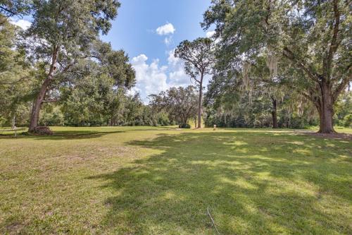 a large grass field with trees in the background at Golf Course Views! Home 10 Mi to Crystal River in Citrus Springs