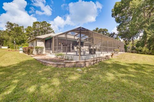 a large glass house on a lawn at Golf Course Views! Home 10 Mi to Crystal River in Citrus Springs