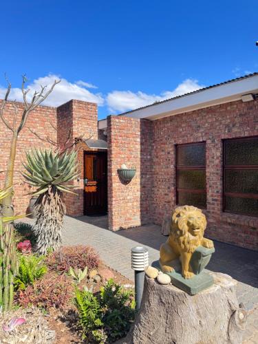 a stone lion statue in front of a brick building at UpperRoom on Sonop in Kirkwood