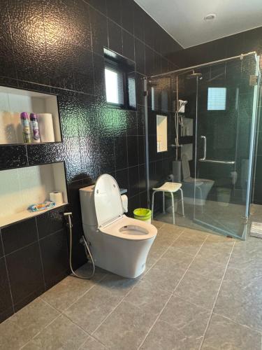un baño con inodoro y ducha en Baan Sam Roi Yot Mountain View Pool Villa, 