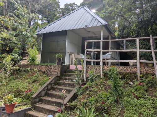 a small building with stairs in front of a garden at Ashokavanam Heritage Village by N Square in Kanthalloor
