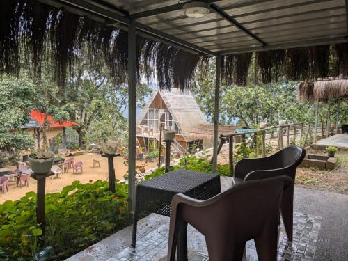a patio with a table and chairs and a house at Ashokavanam Heritage Village by N Square in Kanthalloor