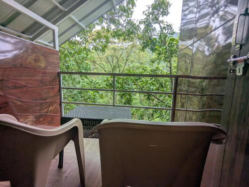 a balcony with a chair and a window with trees at Ashokavanam Heritage Village by N Square in Kanthalloor