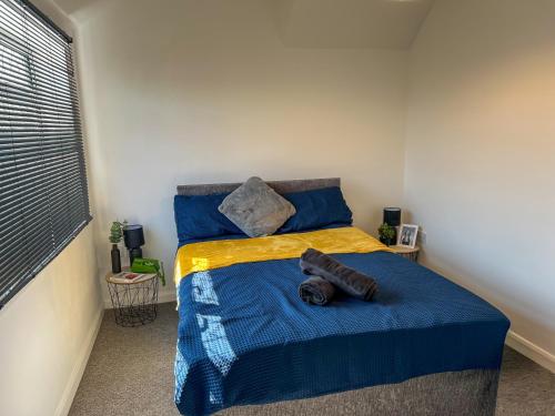 Un dormitorio con una cama con una manta azul. en Lovely house in West Hull, en Hull