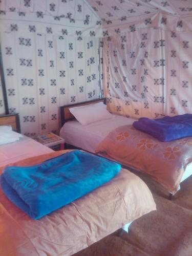 a room with three beds and a wall with patterns at Himalayan Routes Camp Sarchu in Sir Bhum Chun