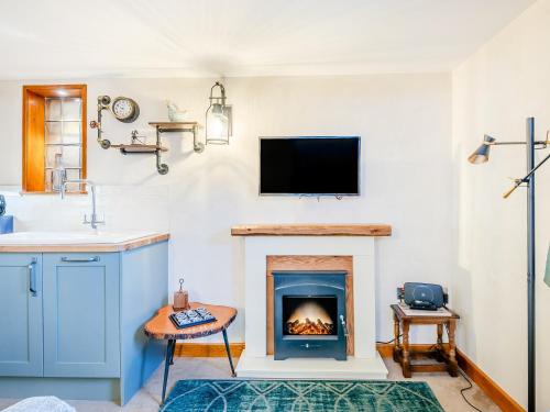 a living room with a fireplace and a tv at The Stable in Welland