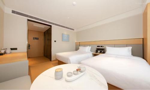 a hotel room with two beds and a table at JI Hotel Beijing West Railway Station Lize Business District in Beijing