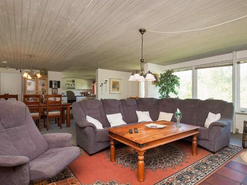 a living room with a couch and a table at 6 person holiday home in Farsø in Farsø