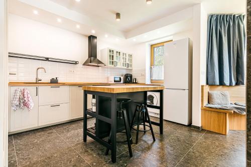a kitchen with a black island and a refrigerator at Hotel Helios in Lipova Lazne