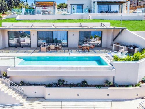 an aerial view of a house with a swimming pool at Villa Andromeda Sunset in Tsoukaladhes