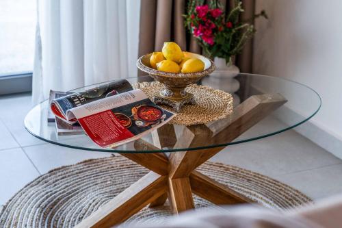 a glass table with a bowl of fruit on top of it at Villa Andromeda Sunset in Tsoukaladhes