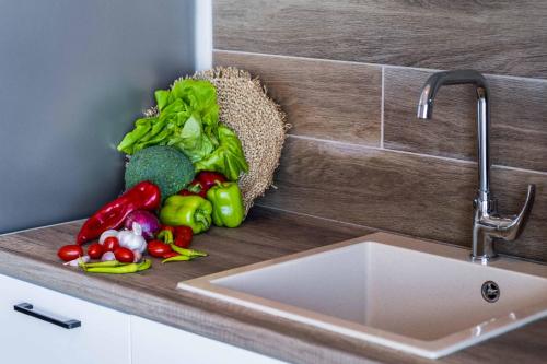 a bunch of vegetables sitting on a counter next to a sink at Villa Andromeda Sunset in Tsoukaladhes