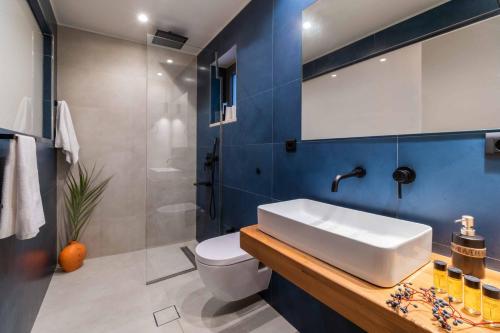 a bathroom with a white sink and a toilet at Villa Andromeda Sunset in Tsoukaladhes