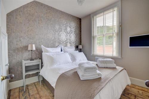 a bedroom with a bed with towels on top of it at Hillsover in Staithes