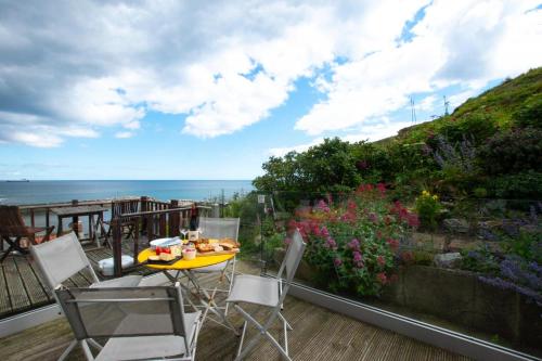 a patio with a table and chairs and the ocean at Hillsover in Staithes