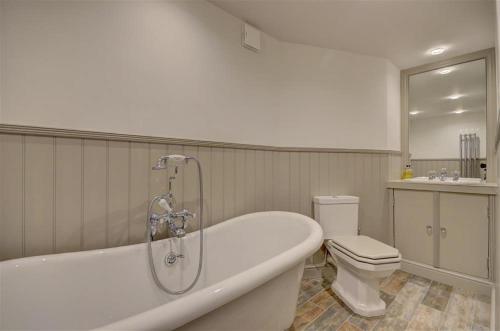 a bathroom with a bath tub and a toilet at Hillsover in Staithes