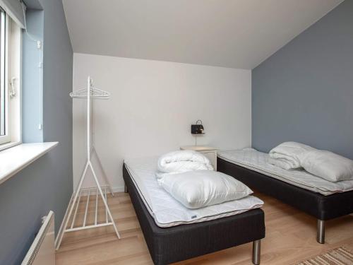 two beds in a small room with a window at 6 person holiday home in Væggerløse in Marielyst