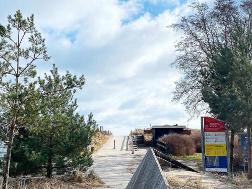 a boardwalk with a sign on the side of it at 6 person holiday home in Væggerløse in Marielyst