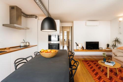 a kitchen and dining room with a table with a bowl of fruit at Design in Liberdade - 2 bedroom Apartment, Marquês Pombal in Lisbon