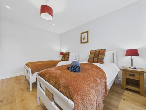 une chambre avec deux lits et une table avec une lampe dans l'établissement Oakwood Lodge, à Matlock