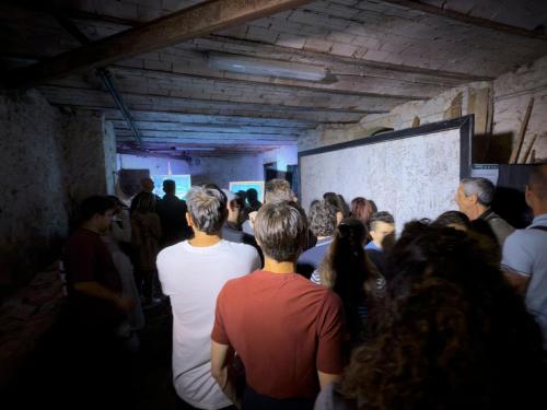 a group of people standing in front of a projection screen at La casa dell’artista di Vittorio Vertone in Pietragalla