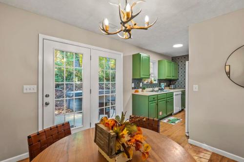 a kitchen with green cabinets and a table and chairs at Comfortable Stay Private Hot tub W Arcade in Sevierville