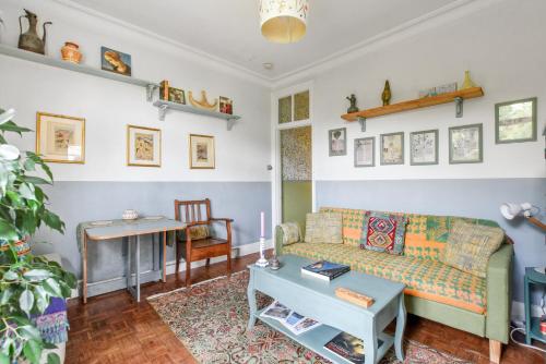 a living room with a couch and a table at Charming London with balcony in London