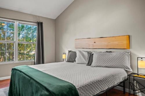 a bedroom with a large bed and two windows at Comfortable Stay Private Hot tub W Arcade in Sevierville