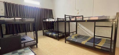three bunk beds in a room with a laptop at The Eighty8 PP in Phnom Penh