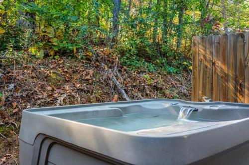 a bath tub sitting in a yard next to a fence at Comfortable Stay Private Hot tub W Arcade in Sevierville
