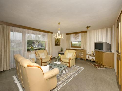 a living room with a couch and chairs and a tv at Apartment in Hinterbichl near Ski Bus in Reutte