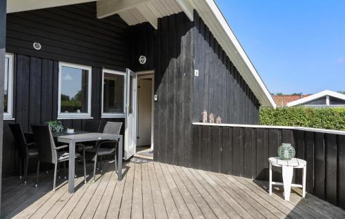 a patio with a table and chairs on a wooden deck at Cozy Home In Sydals With Sauna in Sarup