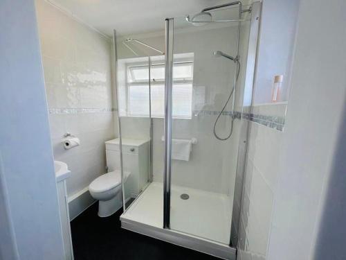 a bathroom with a glass shower and a toilet at Large villa opposite beach in Great Yarnouth in Great Yarmouth
