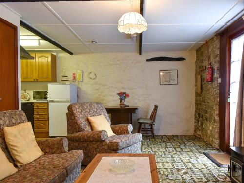 a living room with two chairs and a table at Lower Chinkwell-Uk12426 in Widecombe in the Moor
