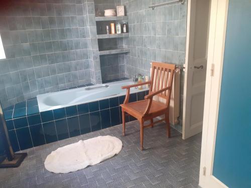 a bathroom with a tub and a chair and a table at Domaine Tombarel - Agritourisme in Brignoles