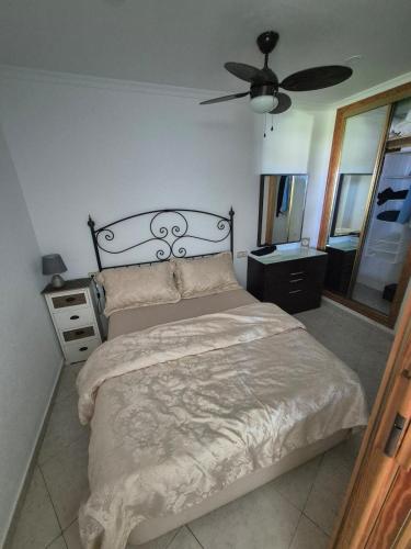 a bedroom with a bed and a ceiling fan at Apartment beachside in Calahonda in Cabopino