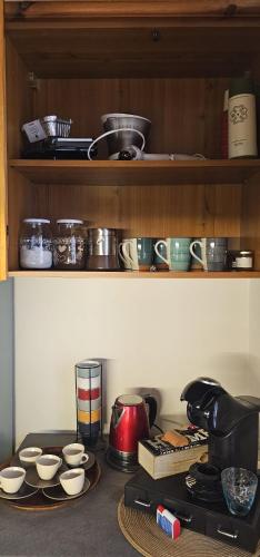 a kitchen counter with bowls and cups on a shelf at Villa Brothers' House in Vimercate