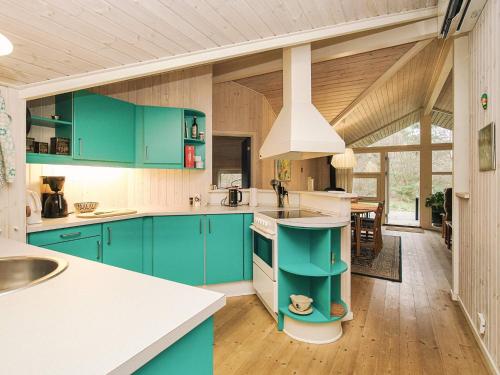 a kitchen with blue cabinets and a stove top oven at Cozy Retreat in Rorvig Haven-By Traum in Rørvig