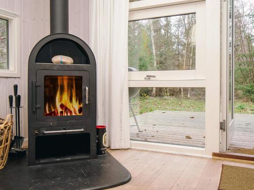 a fireplace in a room next to a window at Cozy Retreat in Rorvig Haven-By Traum in Rørvig