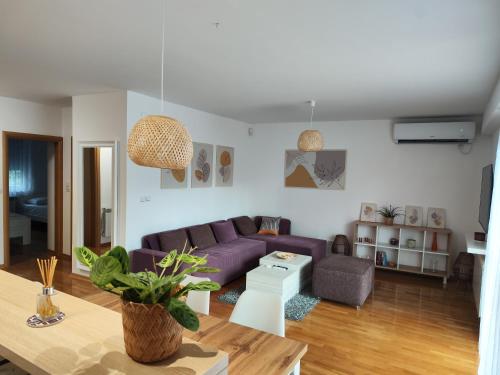 a living room with a purple couch and a table at FinePlace in Skopje