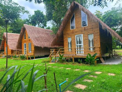 a large wooden house with a thatched roof at The Naturus Eco Home Battambang in Phumĭ Ândong Pring