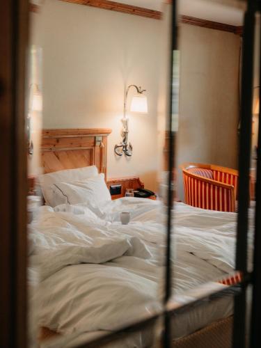 a large white bed in a room with a lamp at Relais & Chateaux Schönegg in Zermatt