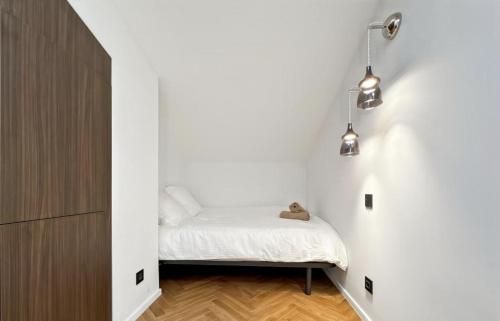 Un dormitorio pequeño con una cama en una pared blanca. en Saint-Tropez Chic, en Saint-Tropez