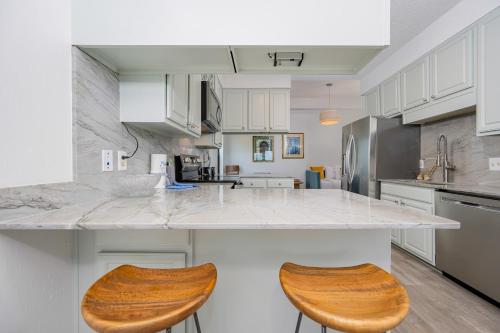 a kitchen with a large counter with two wooden stools at Phoenix II 2151 condo in Romar Beach