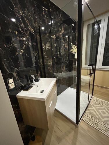 a black and white bathroom with a shower and a sink at Chambre de luxe Afrik a Liège Grande Sale de bain privée check in autonome cuisine partagée in Liège