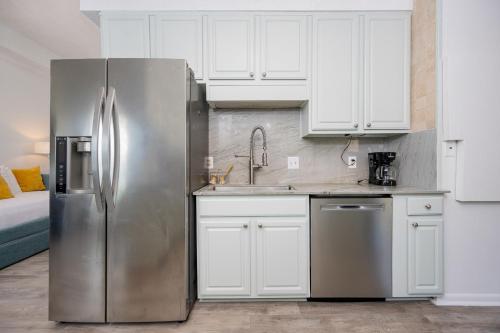 a kitchen with a stainless steel refrigerator and white cabinets at Phoenix II 2151 condo in Romar Beach