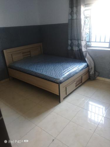 a bed sitting in a room with a window at Easybel Consult Properties in Mowe