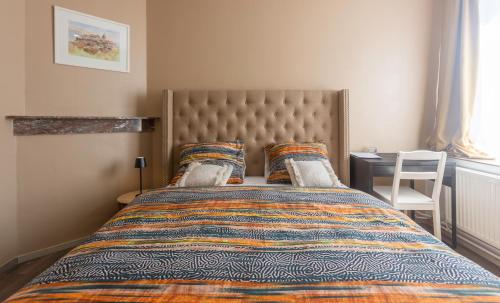 a bedroom with a large bed with a large headboard at Chambre de luxe Afrik a Liège Grande Sale de bain privée check in autonome cuisine partagée in Liège